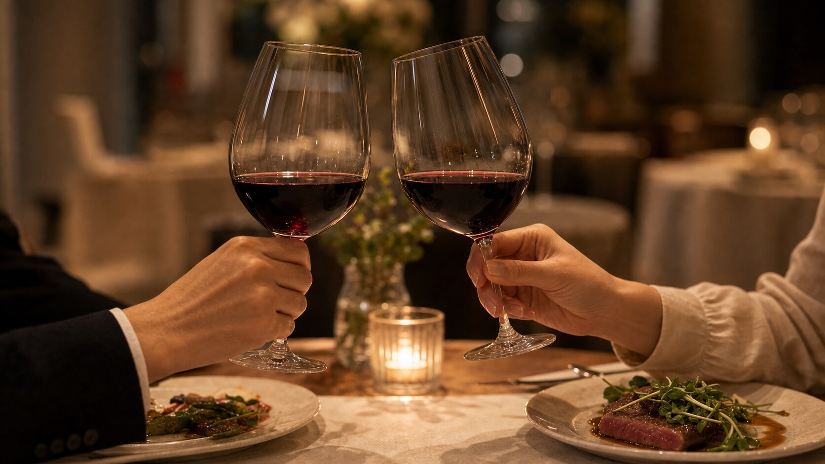 ワインの乾杯でグラスを軽く掲げ、相手と目を合わせる様子